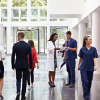 Staff In Busy Lobby Area Of Modern Hospital