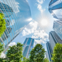Upward view of tall buildings looking into sun
