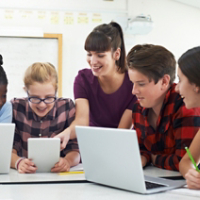 Teenage Students With Teacher In IT Class