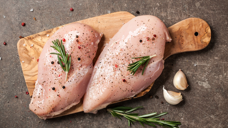 Fresh chicken fillet with spices on cutting board