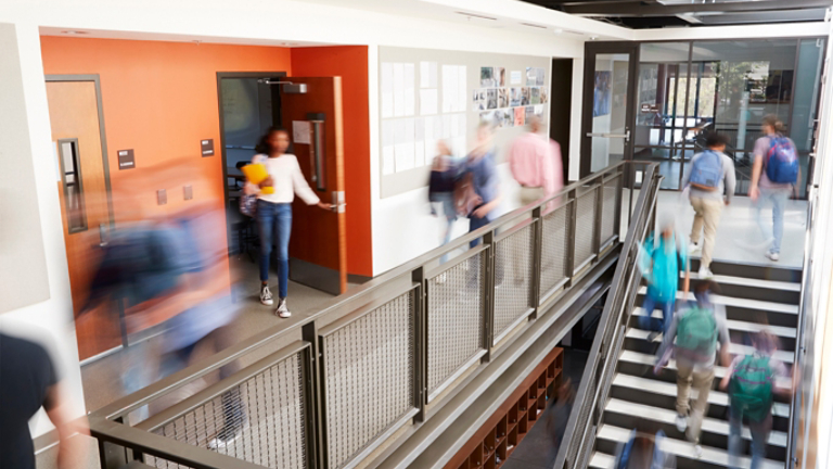 Busy High School Corridor During Recess With Blurred Students And Staff