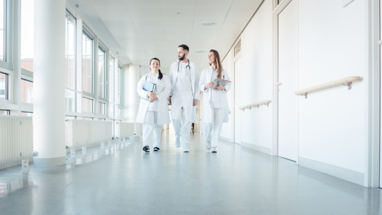 Doctors, two women and a man, in hospital