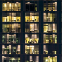 window of the multi-storey building of glass and steel lighting and people within timelapse