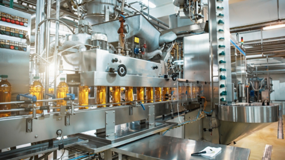 Conveyor belt or line in beverage plant with modern automated industrial machine equipment. Plastic PET bottles with fresh organic juice in factory interior