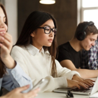 Concentrated international classmates preparing for exams in library