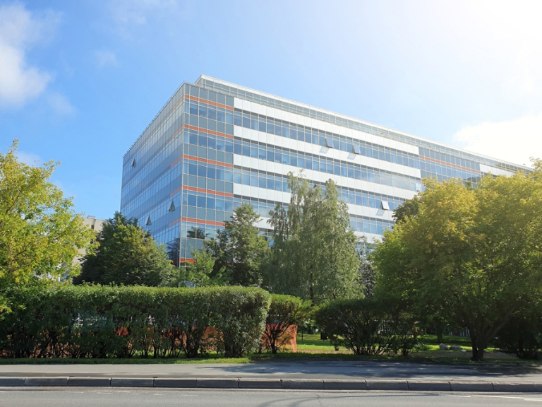 modern office building stands among lush green trees