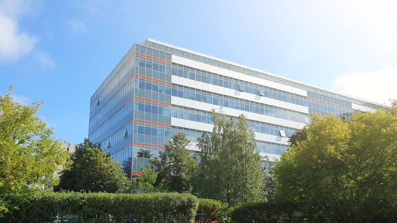 modern office building stands among lush green trees