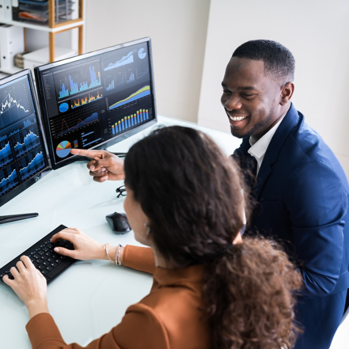 Two Businesspeople Examining Graph On Computer