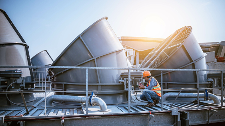 A engineer under checking the industry cooling tower air conditioner is water cooling tower air chiller HVAC of large industrial building to control air system.