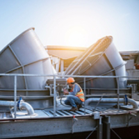 A engineer under checking the industry cooling tower air conditioner is water cooling tower air chiller HVAC of large industrial building to control air system.