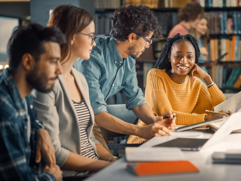 University Library: Diverse Group of Gifted Students Have Discussion, use Laptop, Prepare for Exams Together, Helping, Researching Subjects for Paper Assignment. Happy Young People Study for Future