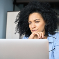 Closeup portrait of serious African American businesswoman using laptop.