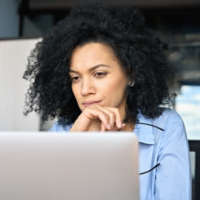 Closeup portrait of serious African American businesswoman using laptop.