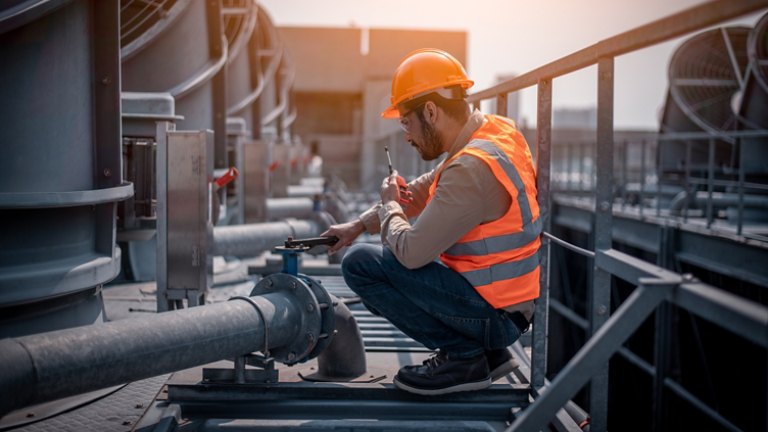 engineer under checking the industry cooling tower air conditioner is water cooling tower air chiller HVAC of large industrial building to control air system.
