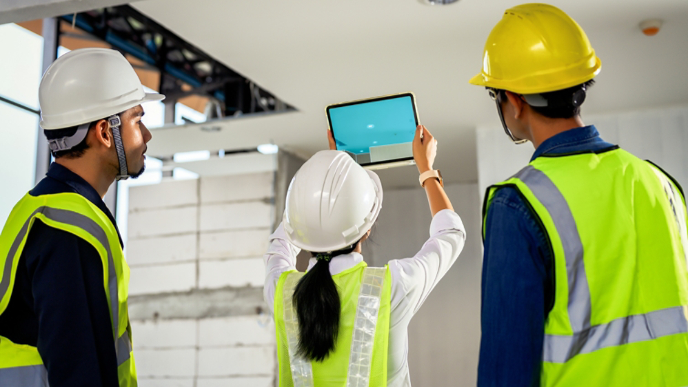 Construction Engineer team uses technology software through tablets to scan building construction and inspection to show augmented reality in work, Building information model, BIM concept