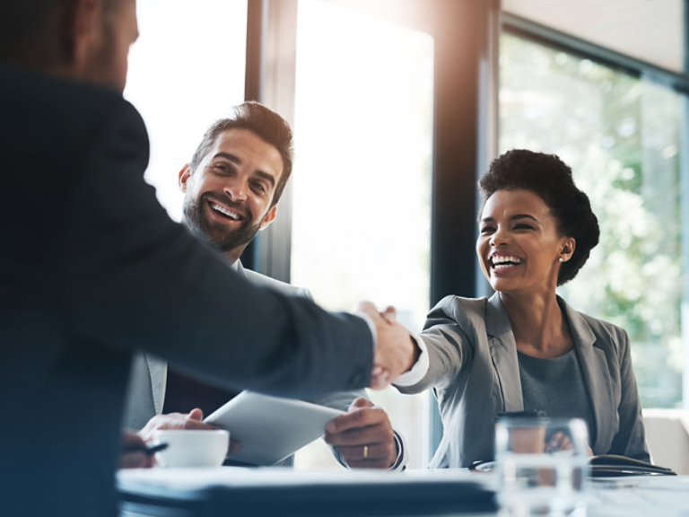 Happy business people, handshake and meeting in teamwork for partnership or collaboration in boardroom. Woman person shaking hands in team recruiting, introduction or b2b agreement at the workplace
