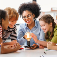 Children gathered around glowing light bulb experiment