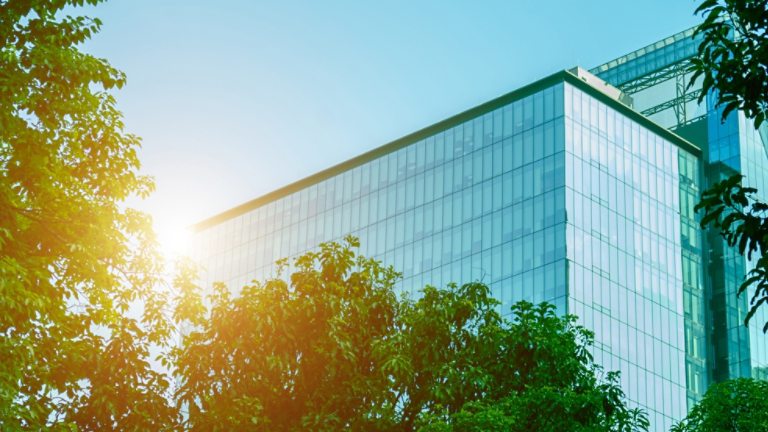 Environmentally friendly office building a sustainable glass building with trees reduces heat and carbon dioxide. Office buildings with a green environment save energy and allow employees to relax.