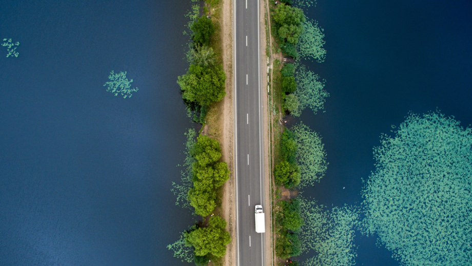 Road over calm blue lake