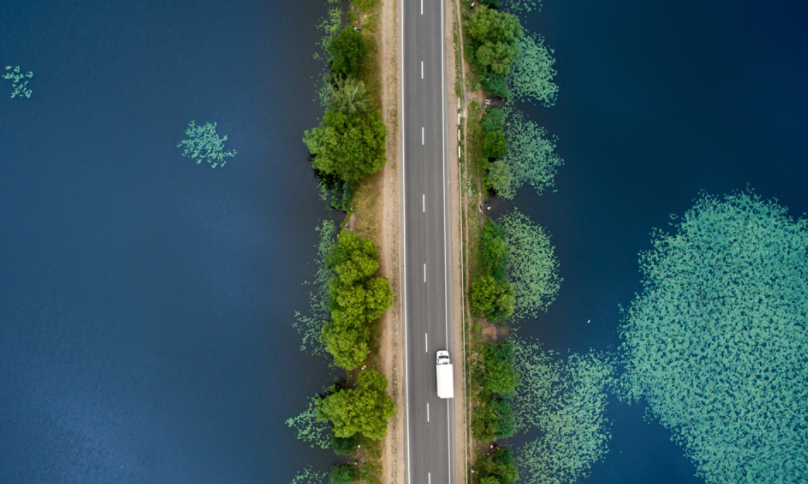 Road over calm blue lake