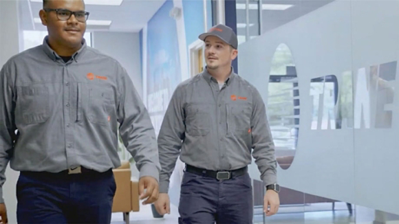 Cody Nelson and technician colleague walking through hallway