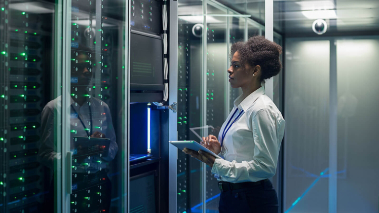 Female technician works on a tablet in a data center