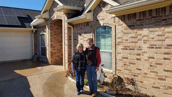 Jesse and Denise standing in front of their home