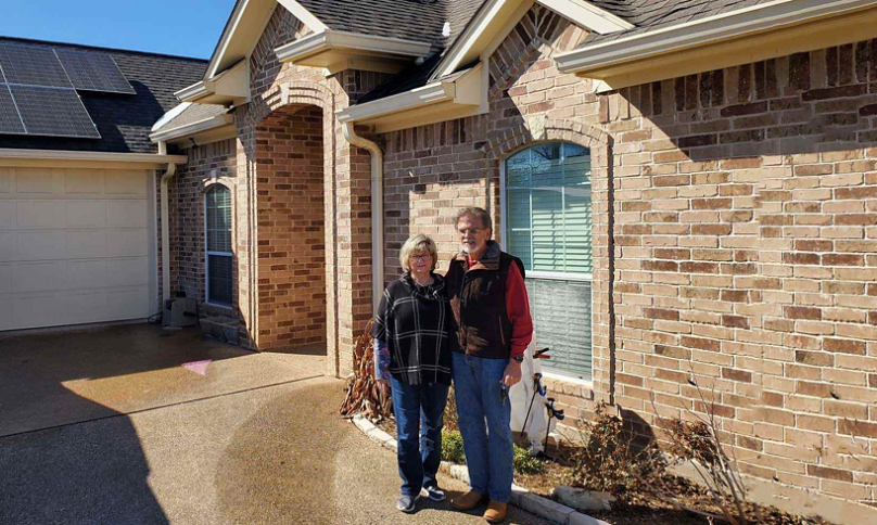 Jesse and Denise standing in front of their home