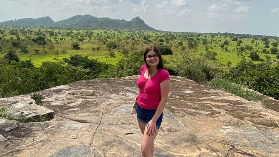 Leah standing on a rocky viewpoint overlooking valley