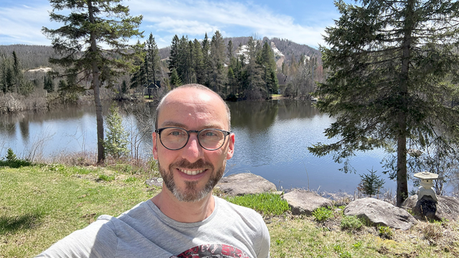 AI Engineer Marc Olivier Fouque in front of scenic lake