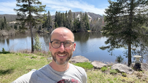 AI Engineer Marc Olivier Fouque in front of scenic lake