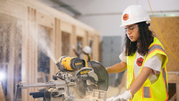 Female carpenter using circular saw