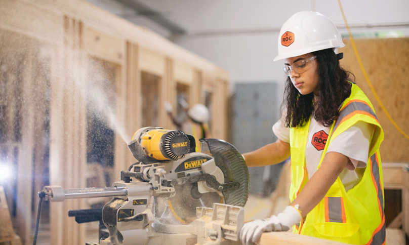 Female carpenter using circular saw