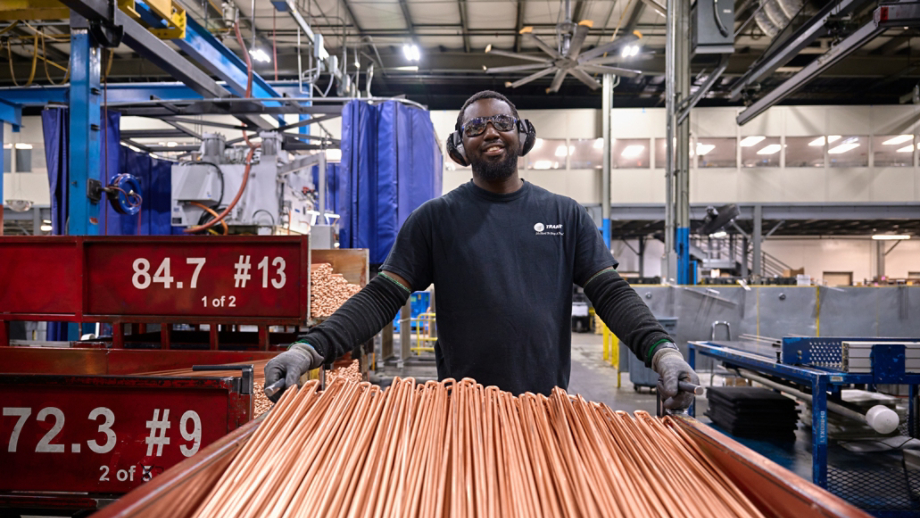 Male employee transporting copper coils 