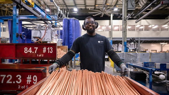 Male employee transporting copper coils 