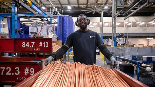 Male employee transporting copper coils 