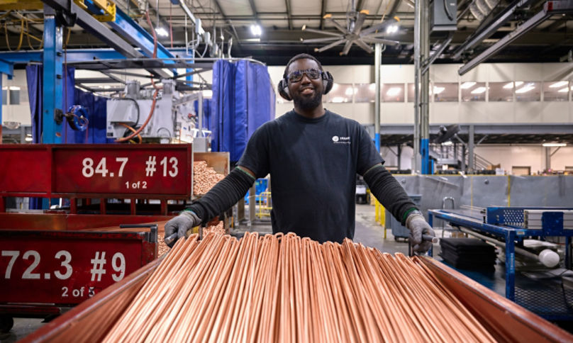 Male employee transporting copper coils 