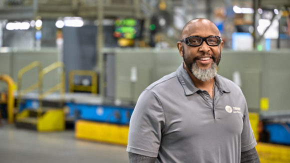Male manufacturing employee smiling 