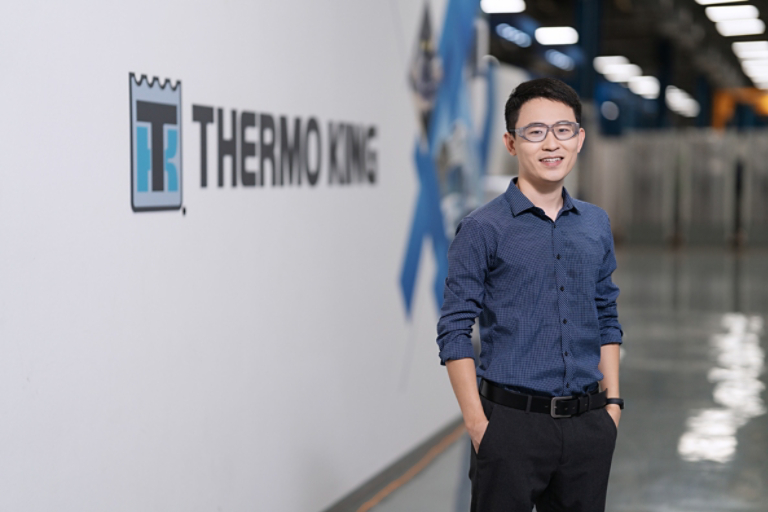 Male employee standing before Thermo King logo