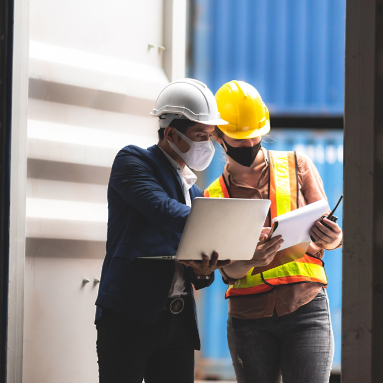 Executive and manager inspecting shipping container