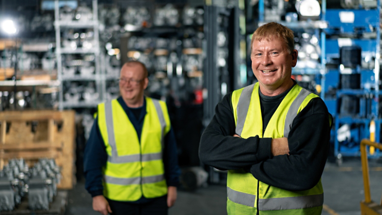 Male employees laughing in parts warehouse