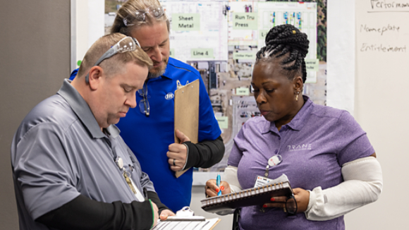 Manufacturing employees taking notes