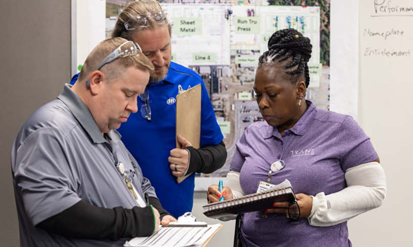 Manufacturing employees taking notes