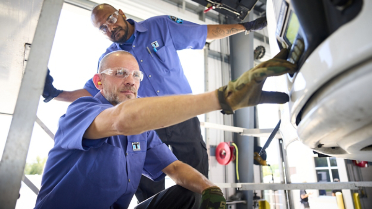 Two male service technicians inspecting Thermo King unit