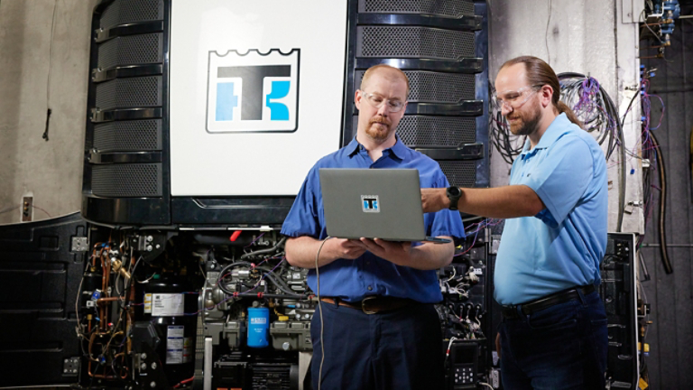 Two male service technicians analyzing data