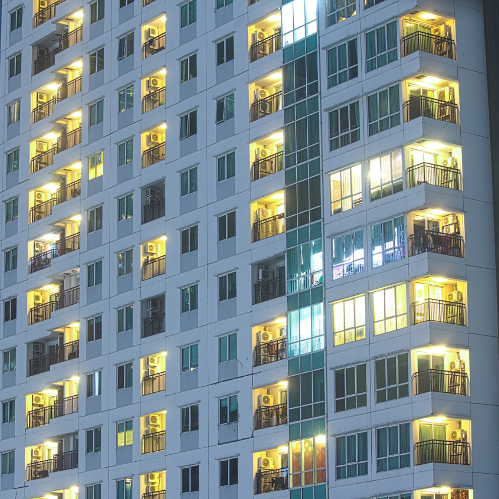 Priivacy concept in highrise apartment windows at night lit in cityscape urban highrise buildings.  Apartment towers for home property and rental.