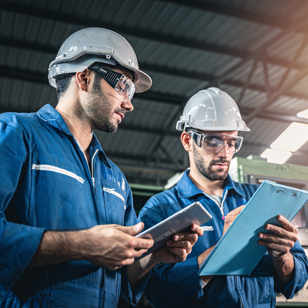 Inspector engineers looking at the document clipboard. Routine maintenance inspection checklist.