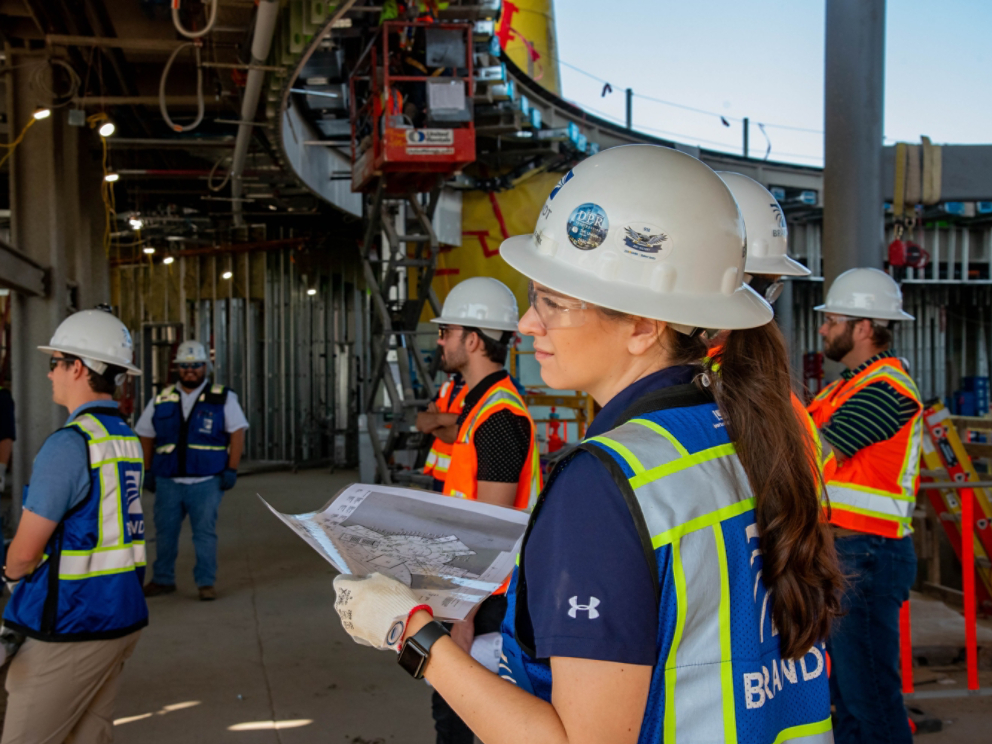 Chrystelle Le Roux on-site with building plans