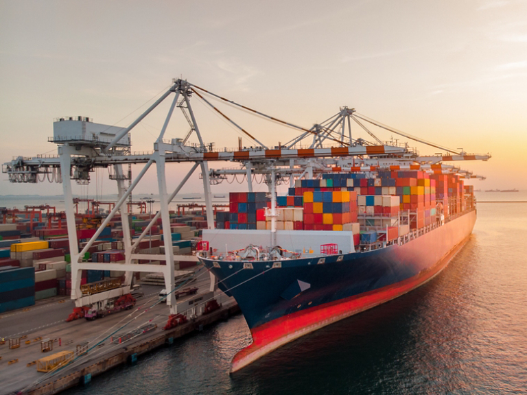 Crane loading cargo container to container ship stand by in the international terminal logistic sea port  concept freight shipping by ship at sunset