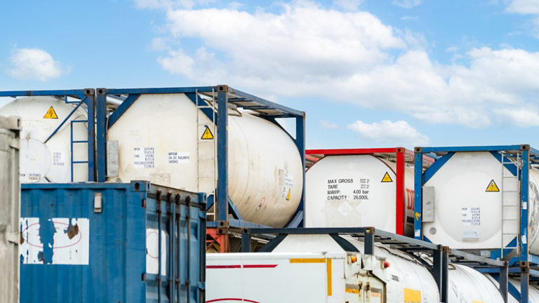 Chemical tank container. ISO tank container for chemical delivery. Bulk liquid transport. Chemical company. Container freight area. Global logistics business. Chemical container for truck transport.